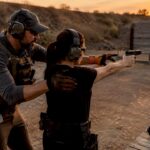 Instructor coaching shooter on firing range