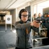Woman practicing point shooting at indoor shooting range