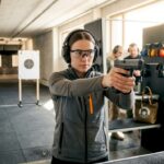 Woman practicing point shooting at indoor shooting range