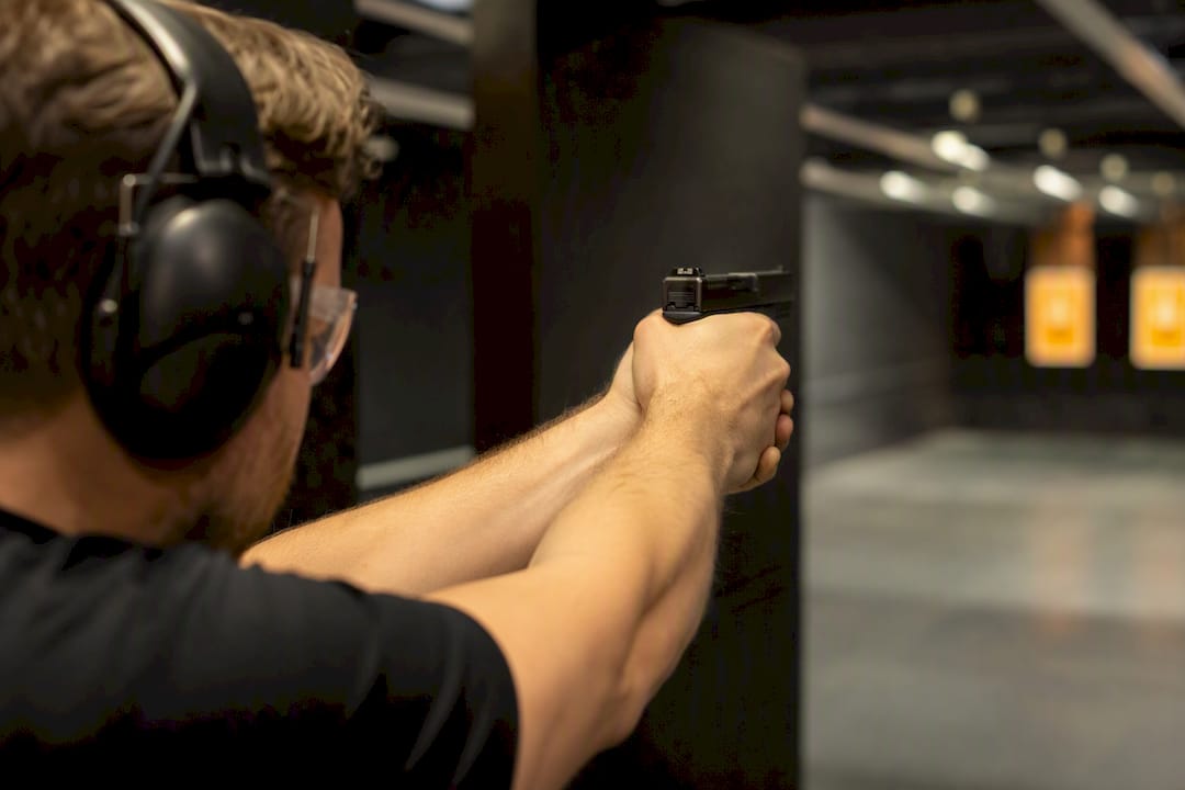 Shooter demonstrating two-handed pistol grip indoors