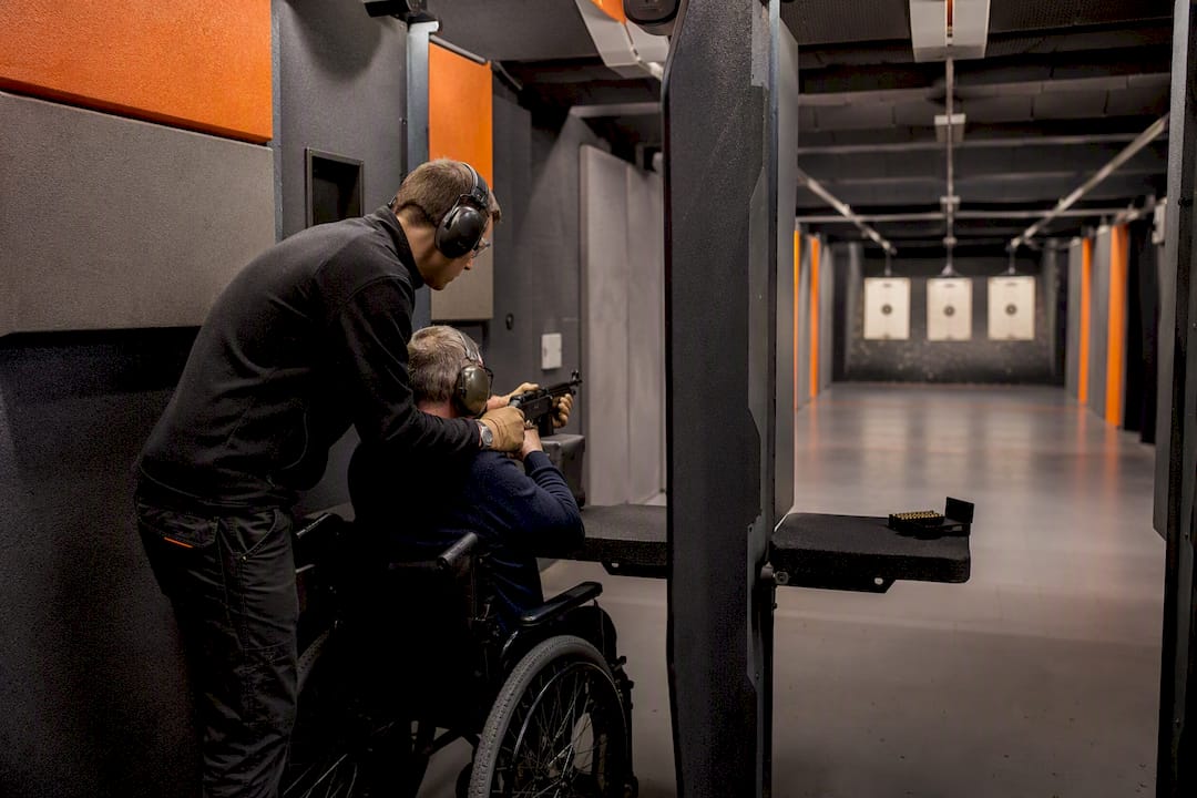 Seated shooting participant with instructor indoors