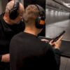 Instructor supervising handgun inspection indoors