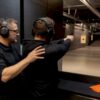 Instructor guiding beginner at indoor range