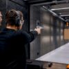Instructor supervising magnum pistol handling indoors