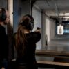 Instructor supervising indoor shooting course practice