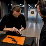 Beginner cleaning firearm under instructor supervision