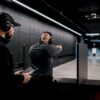 Ohjaaja valvomassa sisätiloissa tapahtuvaa drone-lähetysharjoitusta