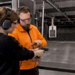 Instructor supervising beginner firearm handling