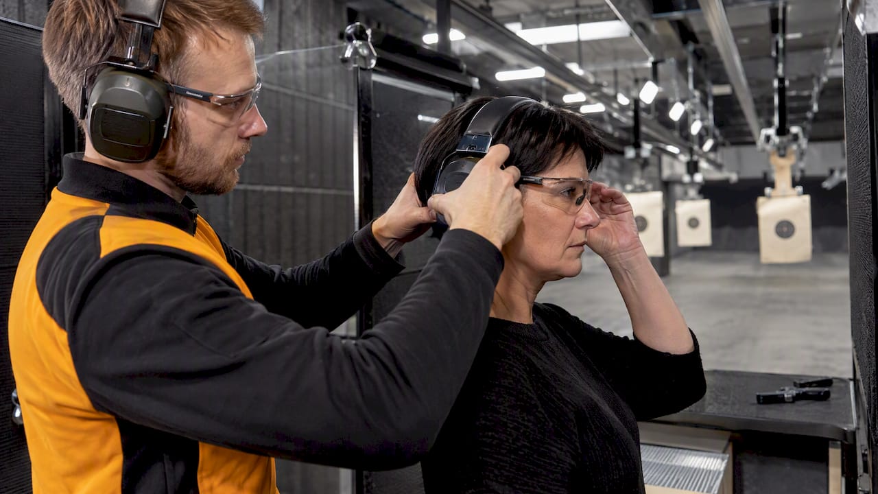 Instructor fitting visitor’s hearing protection