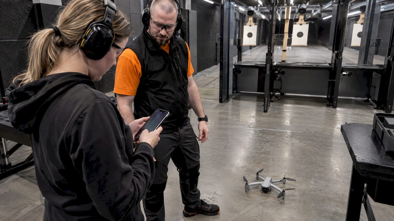 Trainee checking preflight routine beside indoor drone