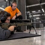 Shooter using an AWP under instructor supervision